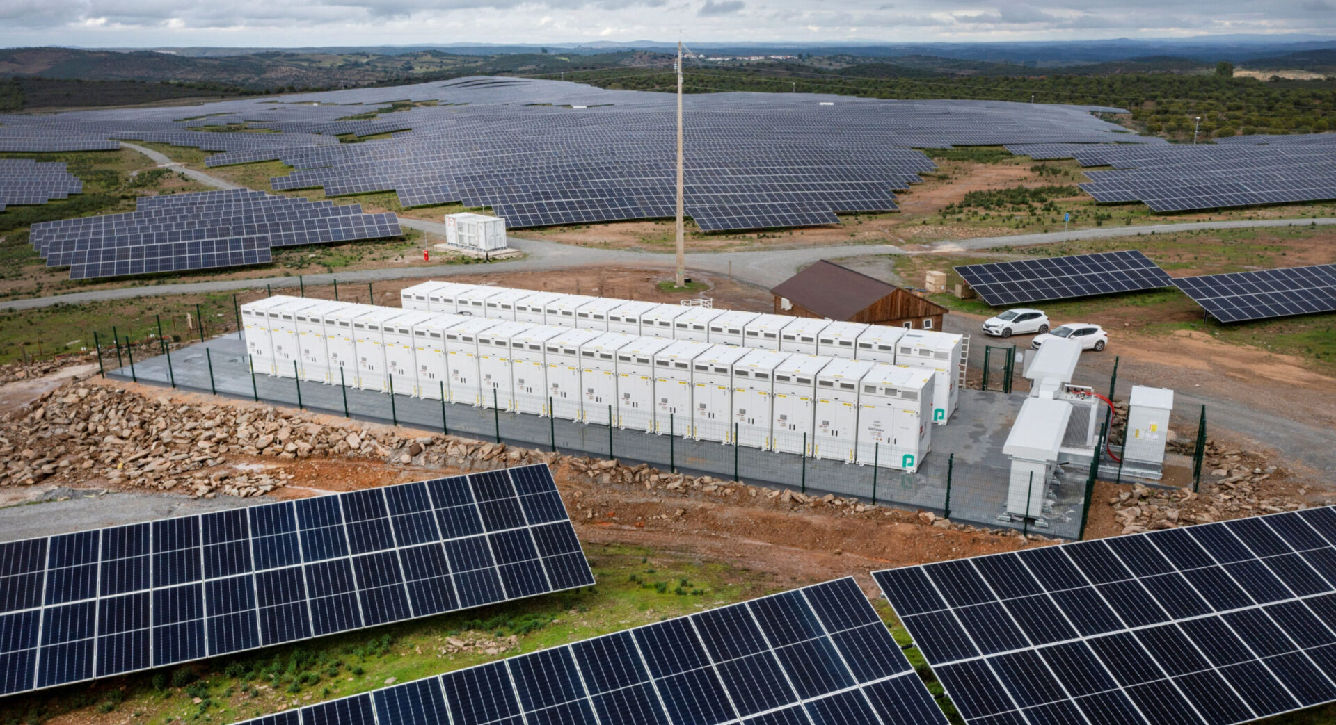 Vista aérea del Parque Solar Pugal, destacando paneles solares y sistema de almacenamiento de energía. Innovación en energía renovable y sostenibilidad.