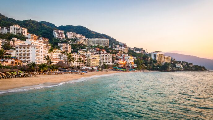 Vista panorámica de Puerto Vallarta, México, con hoteles en la colina y playa. Turismo en México con perspectiva positiva para 2024 según STARC.