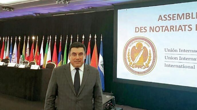 Speakers/headshot

Orador en evento LATAM. Un hombre sonríe frente a banderas y pantalla con texto en francés y español. Conferencia internacional.