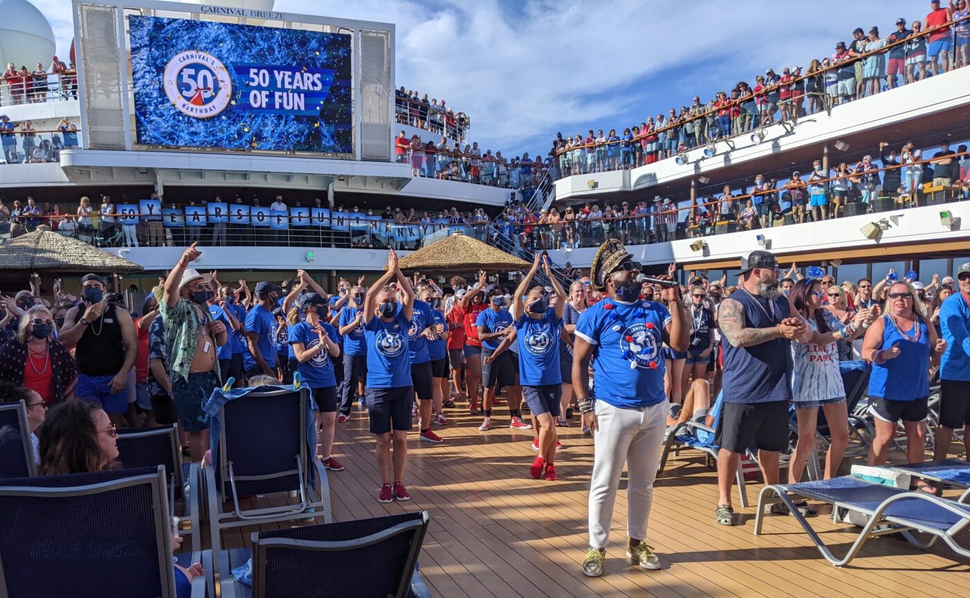 Venue/architecture.

Celebración en crucero con multitud disfrutando de música y baile. Evento especial conmemorando 50 años. Ambiente festivo y alegre.