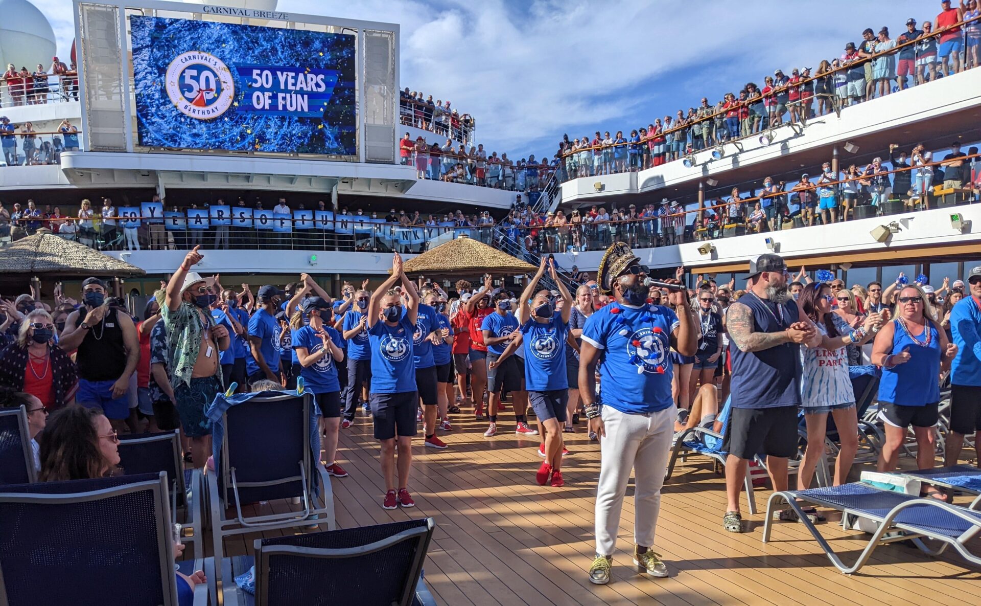 Venue/architecture.

Celebración en crucero con multitud disfrutando de música y baile. Evento especial conmemorando 50 años. Ambiente festivo y alegre.