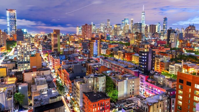 Vista nocturna de Nueva York con rascacielos iluminados. Refleja el aumento del precio de la vivienda en un 68% en la última década.