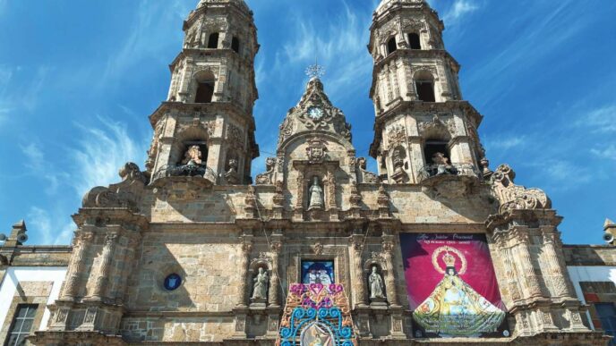 Fachada de la iglesia en Jalisco, ejemplo de arquitectura galardonada. Dos torres adornadas bajo cielo azul. Premio Jalisco de Arquitectura.
