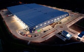 Vista aérea nocturna del mercado industrial de Guadalajara, mostrando la iluminación y la arquitectura moderna de las instalaciones industriales.