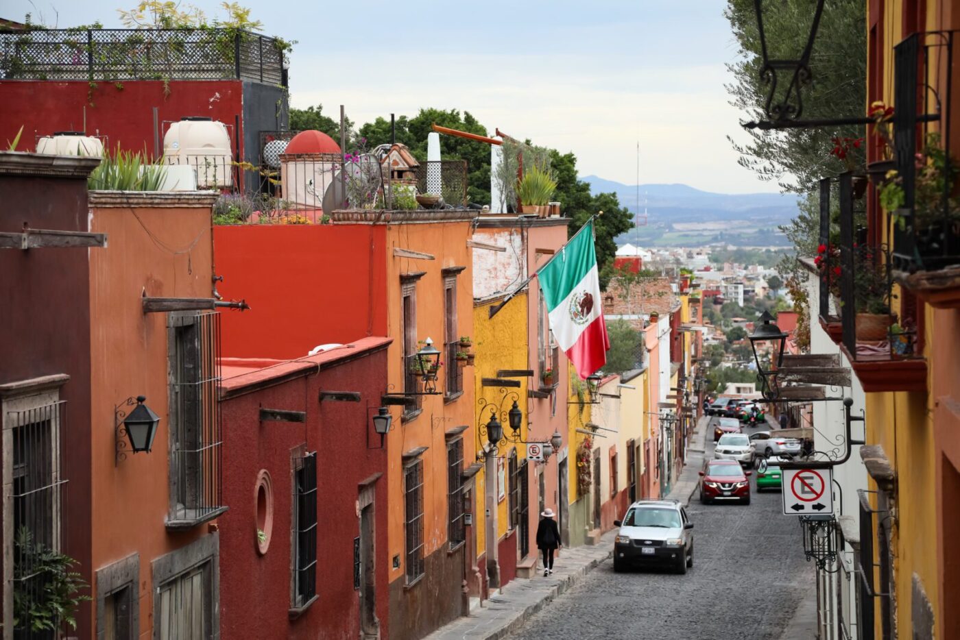 Calle colorida en San Miguel de Allende, México. Arquitectura colonial y bandera mexicana. Inmobiliare Summits explora el real estate en la ciudad.