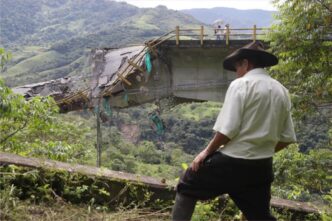 Puente colapsado en zona rural de LATAM. Un hombre observa los daños. Infraestructura afectada impacta el desarrollo urbano de la city.