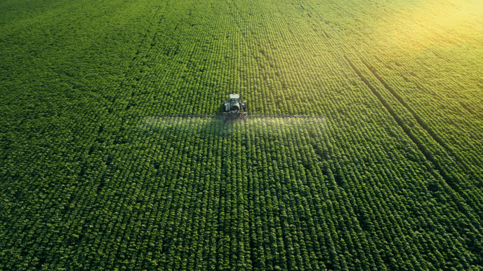 Vista aérea de tractor aplicando fertilizante en campo de fosfatos. Producción sostenible y avance agrícola con tecnología moderna. Imagen verde 125