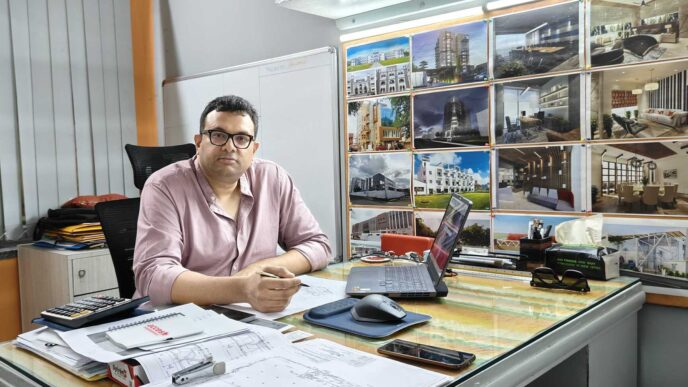 Un arquitecto en su oficina revisando planos para el programa "Hogar, nuevo Hogar" en Nuevo León. Diseño y renovación para 15 mil personas.