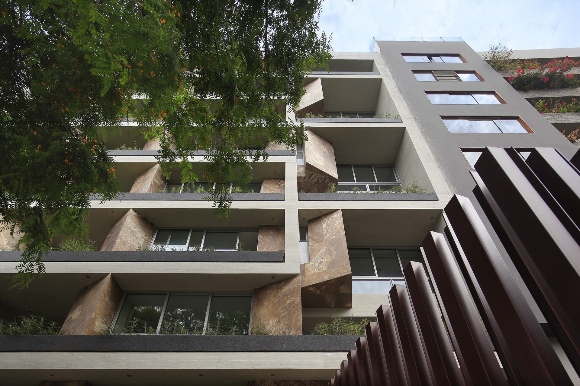 venue/architecture
Arquitectura moderna en LATAM. Fachada de edificio multifamiliar en México con balcones y vegetación. Diseño innovador en real estate.