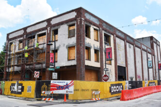 Edificio en renovación impulsando proyectos mixtos en Kansas City. Obra en construcción con andamios y señalización. Vacantes retail en la zona.