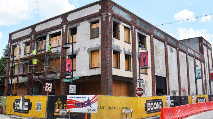 Edificio en renovación impulsando proyectos mixtos en Kansas City. Obra en construcción con andamios y señalización. Vacantes retail en la zona.