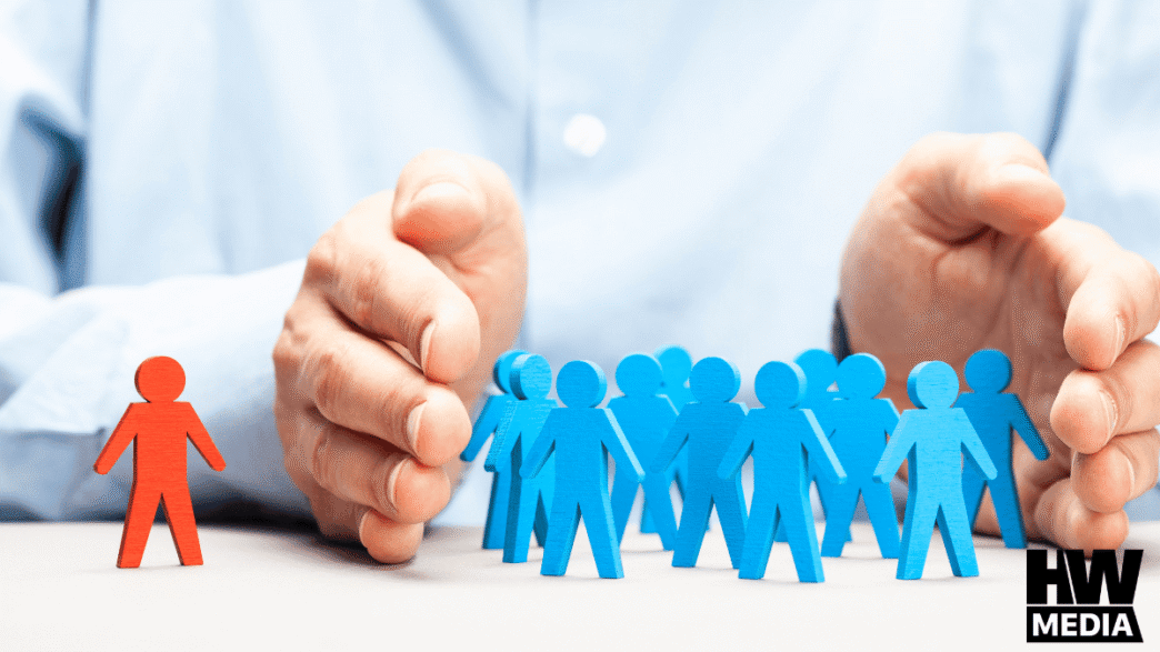 Gestión inmobiliaria: Figura roja destacada entre figuras azules protegidas por manos. Rechat y Loft47: revolución en el sector, liderazgo y seguridad.