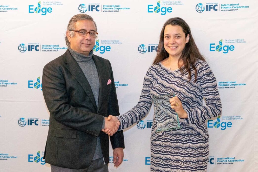 Entrega de reconocimiento en Inmobiliare Summits. Dos personas se dan la mano frente a logos de patrocinadores. Evento real estate en México.