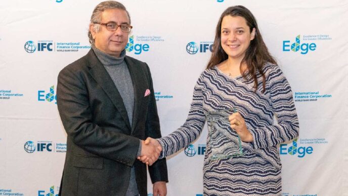 Entrega de reconocimiento en Inmobiliare Summits. Dos personas se dan la mano frente a logos de patrocinadores. Evento real estate en México.