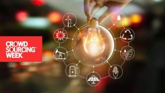 Reforma eléctrica y crowdfunding sustentable: Mano sosteniendo bombilla rodeada de iconos de energías renovables. Crowdsourcing Week apoya energía limpia.