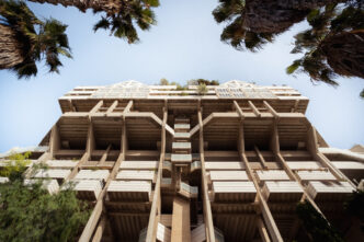 Arquitectura brutalista en Valencia, España, captada desde abajo con palmeras en el cielo. Festival Open House Valencia arquitectura brutalista.