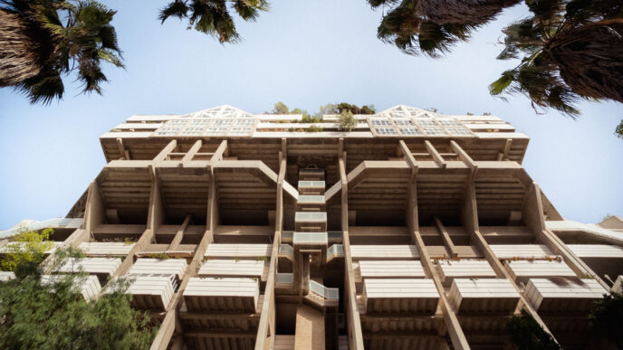Arquitectura brutalista en Valencia, España, captada desde abajo con palmeras en el cielo. Festival Open House Valencia arquitectura brutalista.