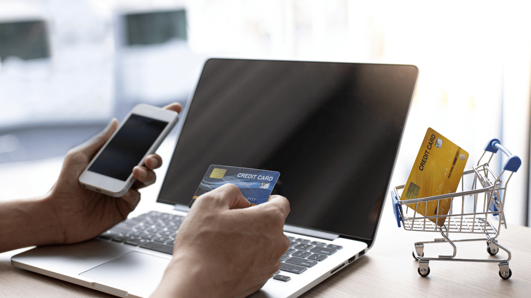 Persona comprando en línea con tarjeta de crédito y smartphone. Comercio electrónico, pagos digitales, compras seguras.