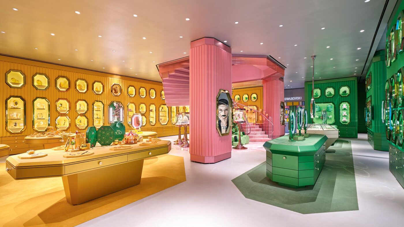 Interior de tienda retail Swarovski, con exhibidores dorados, rosados y verdes. Refleja la situación actual del retail en 2024 y sus perspectivas.