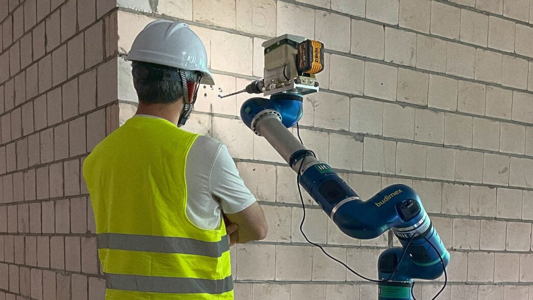 Venue/architecture.

Obrero supervisa robot perforando pared. Innovación tecnológica en construcción. #realestate #venue #LATAM