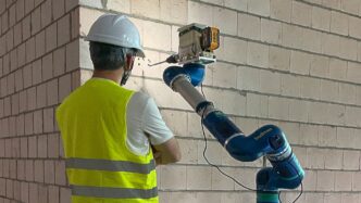 Venue/architecture.

Obrero supervisa robot perforando pared. Innovación tecnológica en construcción. #realestate #venue #LATAM