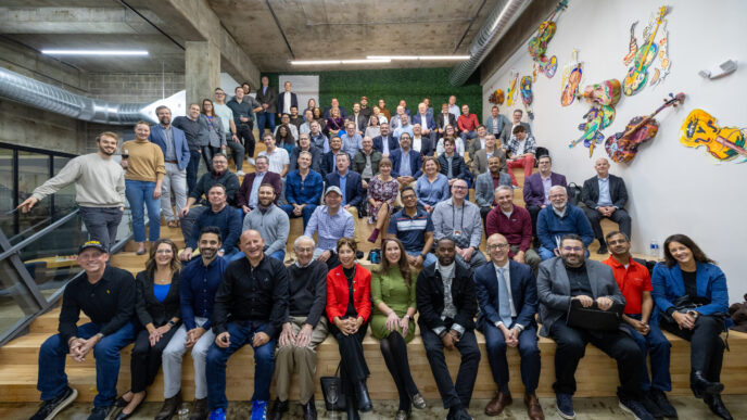 Grupo diverso en escalera, celebrando expansión de Sagard en Manhattan, con implicaciones LATAM. Ambiente moderno y colaborativo. Inversión y negocios.