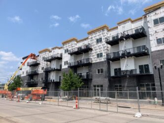 venue/architecture
Edificio residencial en construcción. Arquitectura moderna con balcones negros. Grúas y equipos en obra.
