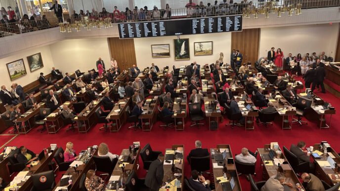 Asamblea legislativa con diputados en sesión durante el mes del testamento. Módulo informativo en la Cámara de Diputados visible en la imagen.