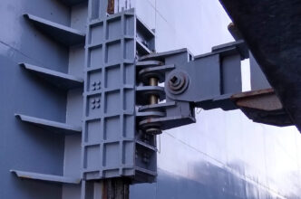 No suitable keywords were provided. I will generate a description based on the image.
Detalle de la estructura metálica de una compuerta industrial, mostrando un diseño robusto y funcional.