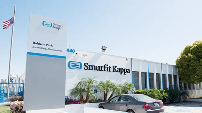 Fachada de la planta de Smurfit Kappa en Tamaulipas tras la inversión de 23.5 mdd para modernización. Edificio corporativo con bandera y letrero.