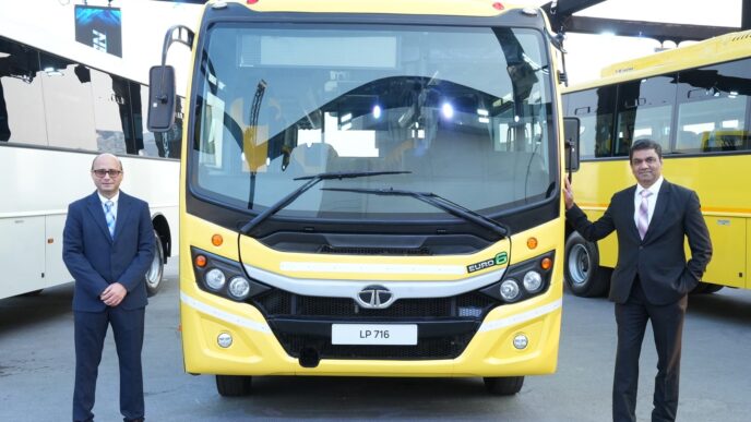 Presentación de autobús Tata Motors Euro 6 LP 716 amarillo. Dos hombres de pie frente al vehículo, mostrando la transición a vehículos comerciales Euro 6.
