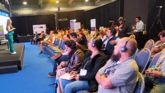 Ponente en Inmobiliare Summits, conferencia de real estate en México. Público atento con audífonos. Evento LATAM en un venue amplio.