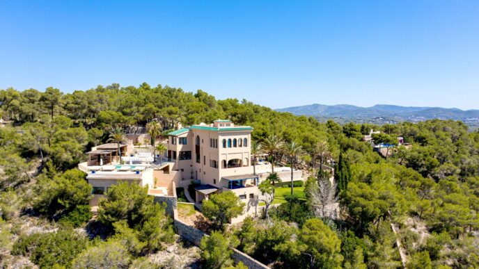 Vista aérea de lujosa vivienda en España, rodeada de árboles. Tendencias en compra de vivienda 2024. Arquitectura moderna y piscina visible.