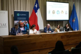 Panel con Tinsa Chile y Universidad de San Sebastián. Apoyo al mercado inmobiliario chileno. Expositores y bandera de Chile presentes.