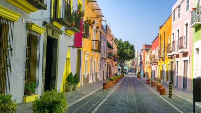 Calle pintoresca en México, con casas de colores vibrantes. Arquitectura colonial y ambiente turístico. Monterrey lidera el mercado residencial.