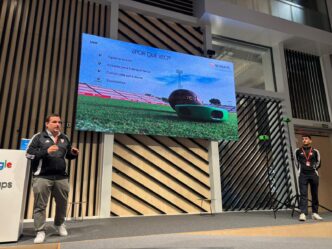 Presentación Torre Sevilla: Dos hombres en un escenario con pantalla mostrando el Sevilla FC y tecnología Veo para análisis deportivo.