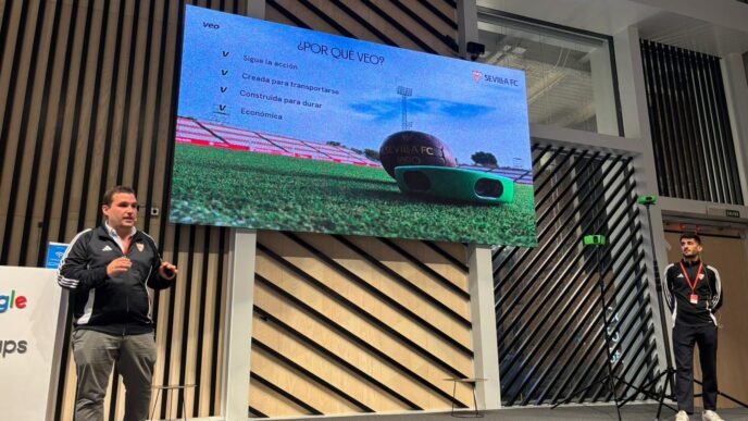 Presentación Torre Sevilla: Dos hombres en un escenario con pantalla mostrando el Sevilla FC y tecnología Veo para análisis deportivo.