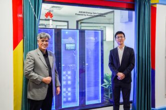Inauguración del centro de datos ASEAN Huawei, clave en la transformación cero carbono. Dos personas frente a servidores Huawei FusionModule.