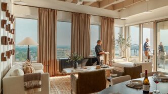 Interior de departamento moderno con ventanales, sala de estar, comedor y balcón. Transformación oficinas a viviendas en LATAM, diseño elegante.