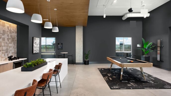 Espacio de recreación con mesa de billar, barra con taburetes y decoración moderna. Transformación digital en real estate y Behr Paint.