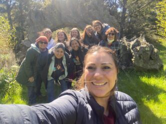 Grupo diverso celebra el turismo de romance en Querétaro, posando sonrientes frente a un arco natural. Estrategia para reactivar el sector turístico.