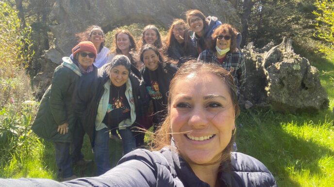 Grupo diverso celebra el turismo de romance en Querétaro, posando sonrientes frente a un arco natural. Estrategia para reactivar el sector turístico.