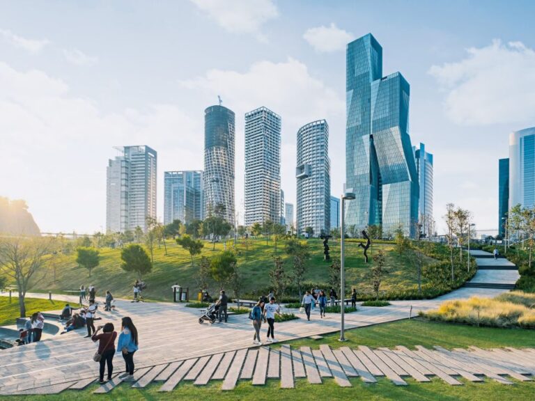 Urban park with modern skyscrapers in the background.