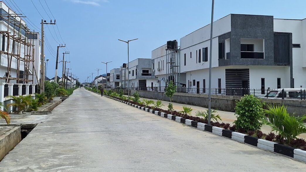 Vista de calle en Nigeria con casas modernas, ilustrando la inversión inmobiliaria de Vira Property y su redefinición del sector. Urbanismo y diseño.