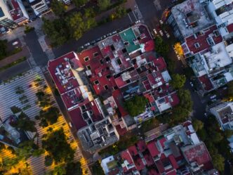 Vista aérea de viviendas residenciales en CDMX con techos rojos y áreas verdes. El segmento más comercializado en la Ciudad de México se aprecia aquí.