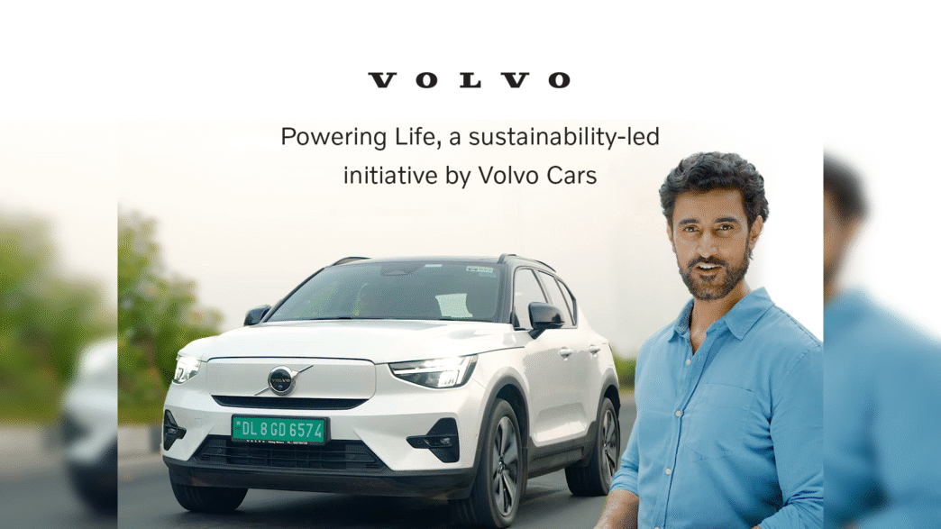 Volvo apuesta a movilidad sostenible India: SUV eléctrico blanco y hombre sonriendo. Iniciativa de Volvo Cars para un futuro más ecológico.