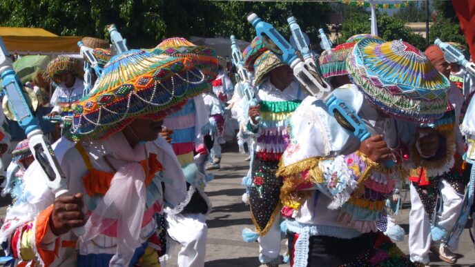 Grupo de danzantes con trajes típicos y coloridos sombreros durante una celebración en México. Celebración Waldos en el norte de México.