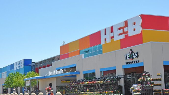Vista exterior de una tienda H-E-B, mostrando la fachada colorida y la entrada con flores. Inversión en Edomex, similar a Walmart de México.