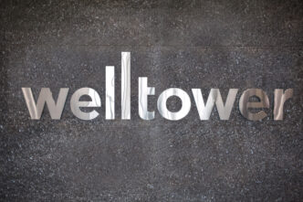 Logotipo de Welltower en pared texturizada. Welltower redefine su portafolio hacia residencias para adultos mayores, un sector en crecimiento.