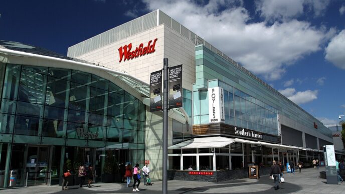 Venue/architecture.

Fachada del centro comercial Westfield, posible sede de Inmobiliare Summits. Arquitectura moderna en ciudad, con tiendas y restaurantes.